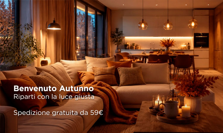 Cosy autumn living room and open-plan kitchen with warm pendant lights, plush sofa, cushions, throws and candles, evening ambience