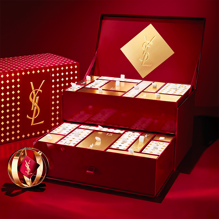 Una GIF animata che mostra regali di trucco e profumi YSL apparire progressivamente attorno a un lussuoso calendario dell'Avvento aperto.
