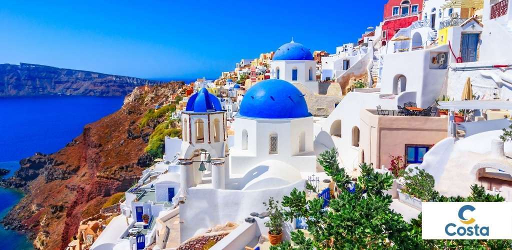 Santorini Oia panorama: whitewashed buildings and blue-domed churches above the caldera and deep blue Aegean Sea