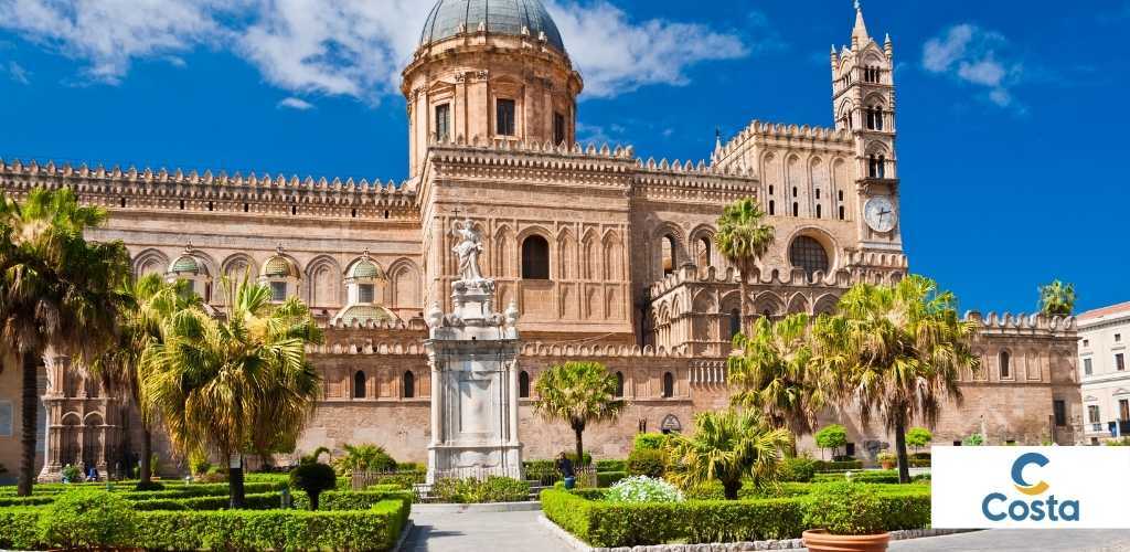 Palermo Cathedral with palm trees and manicured gardens under a bright blue sky, Costa cruise logo at bottom right