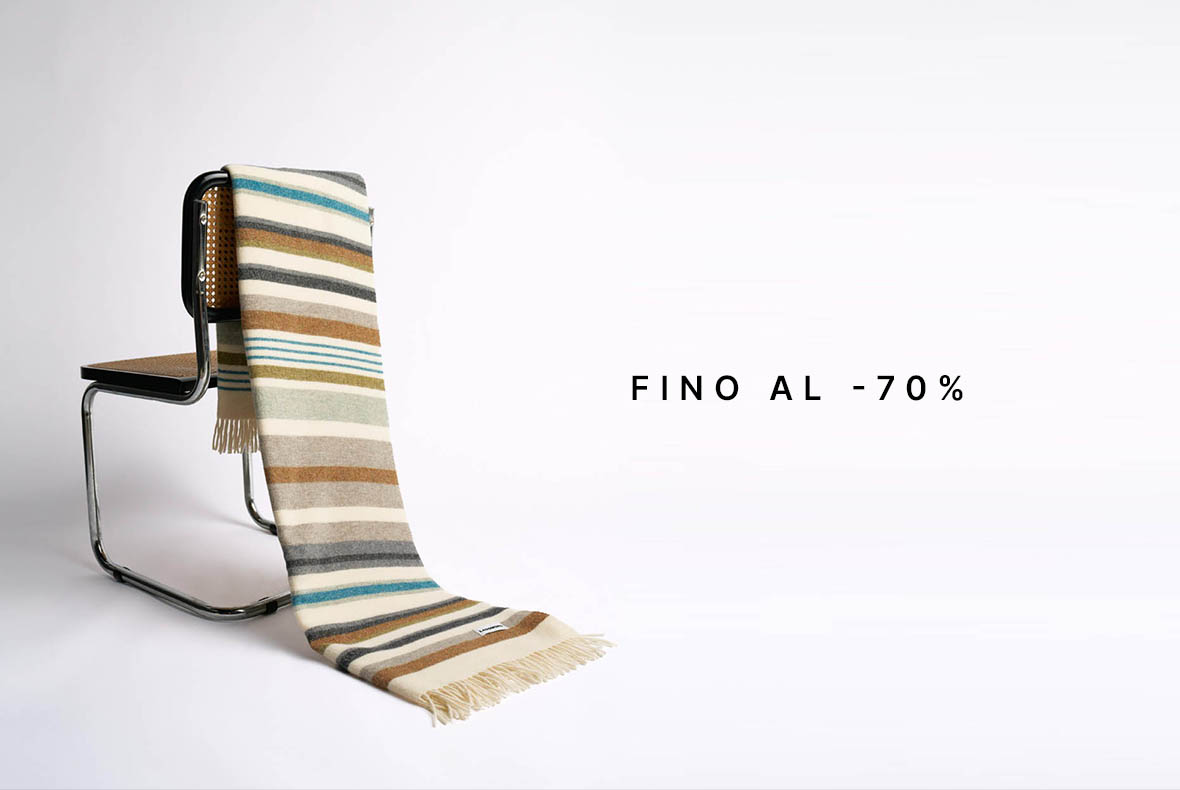 Striped wool throw draped over modern cantilever chair with 'up to 70% off' sale text
