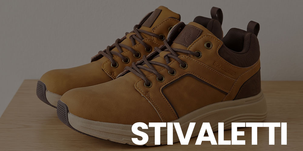 Pair of tan leather casual ankle boots with brown laces on a wooden surface
