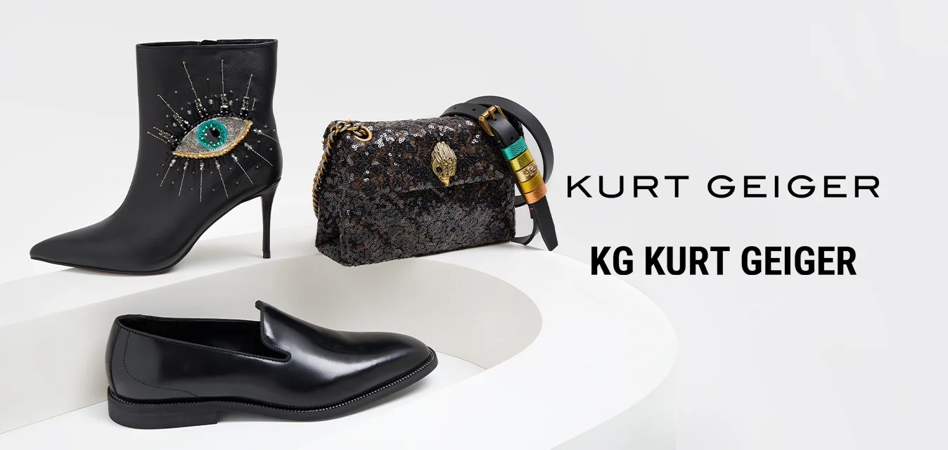 Stivale in pelle nera alla caviglia con design a occhio oro e smeraldo, scarpa nera slip-on e borsa nera in paillettes con chiusura decorativa.