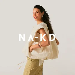 Giovane donna con capelli ricci indossa pantaloni cargo beige, top lavorato a maglia senza maniche, gilet crema oversize, sandali e gioielli d'argento, in piedi con le mani nelle tasche.