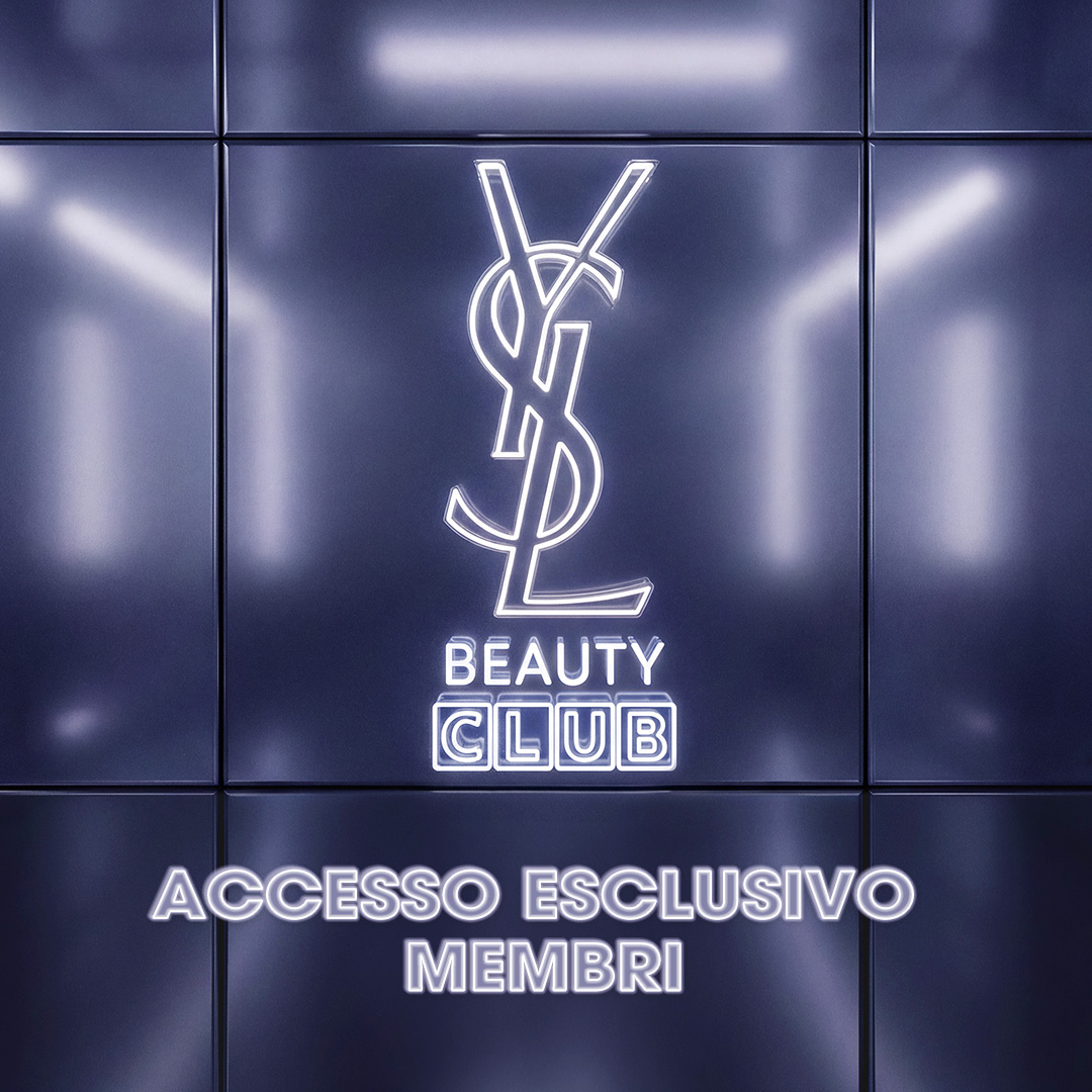 Un logo YSL Beauty Club al neon bianco luminoso su una parete metallica viola riflettente.