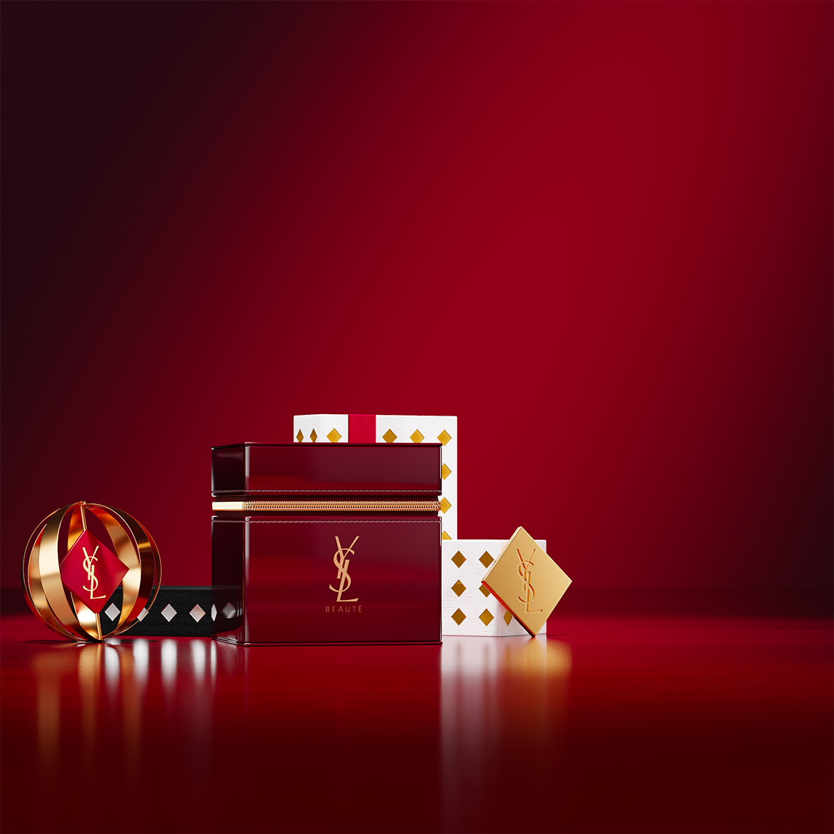 Un beauty case YSL bordeaux lucido esposto con scatole regalo festive e un ornamento dorato su una superficie rossa riflettente.