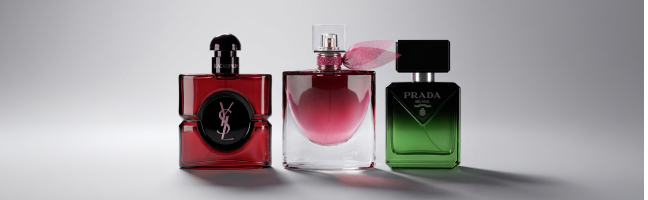 Scatto pubblicitario che ritrae tre profumi dei marchi Yves Saint Laurent, Lancôme e Prada affiancati.