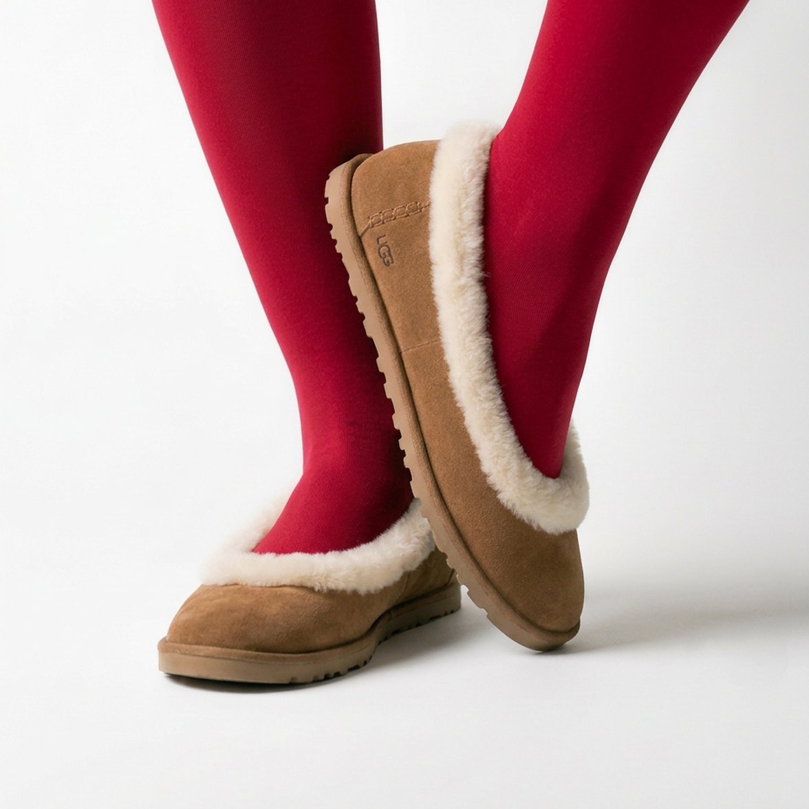 Pantofole UGG in suede con bordo in montone, indossate con calze rosse