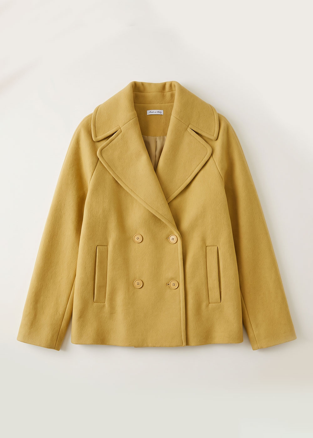 Mustard yellow double-breasted wool-blend pea coat with wide lapels and slit pockets, flat-lay on pale background