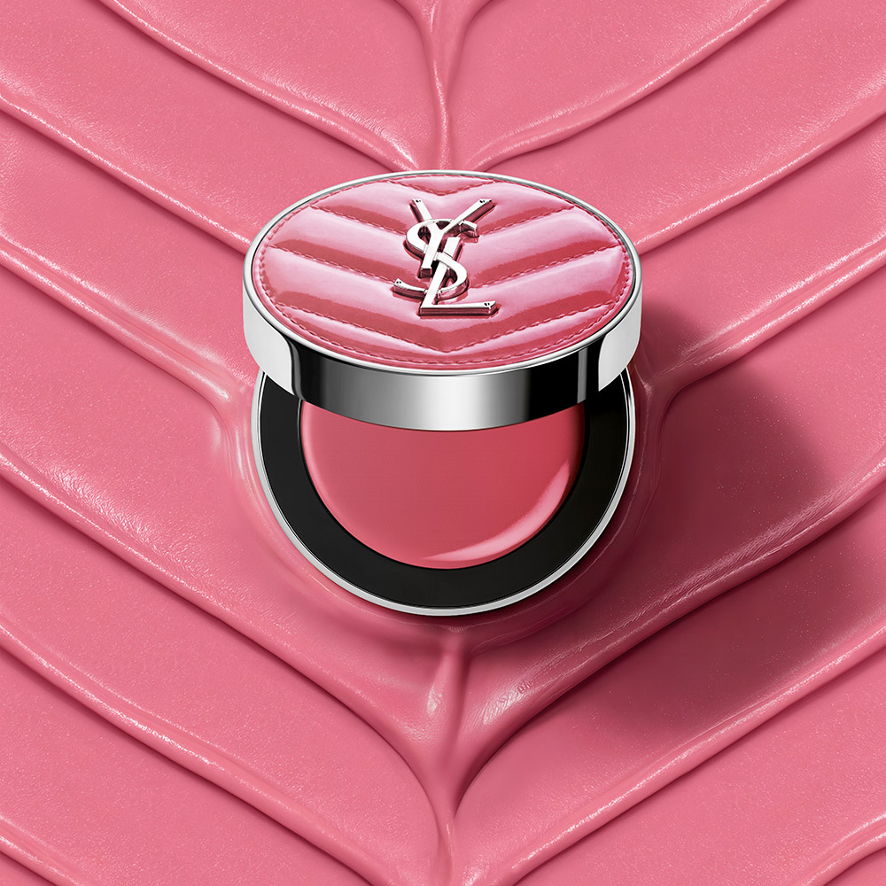 Un blush compatto rosa YSL aperto adagiato su uno sfondo cremoso e testurizzato rosa coordinato.