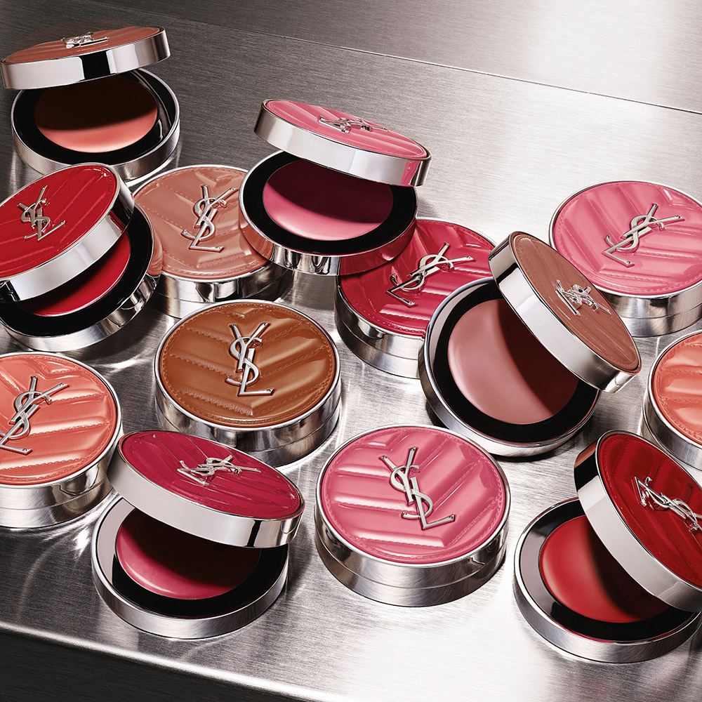 Numerosi astucci di blush YSL aperti e chiusi esposti in una variet&agrave; di sfumature rosa, corallo e rosso.