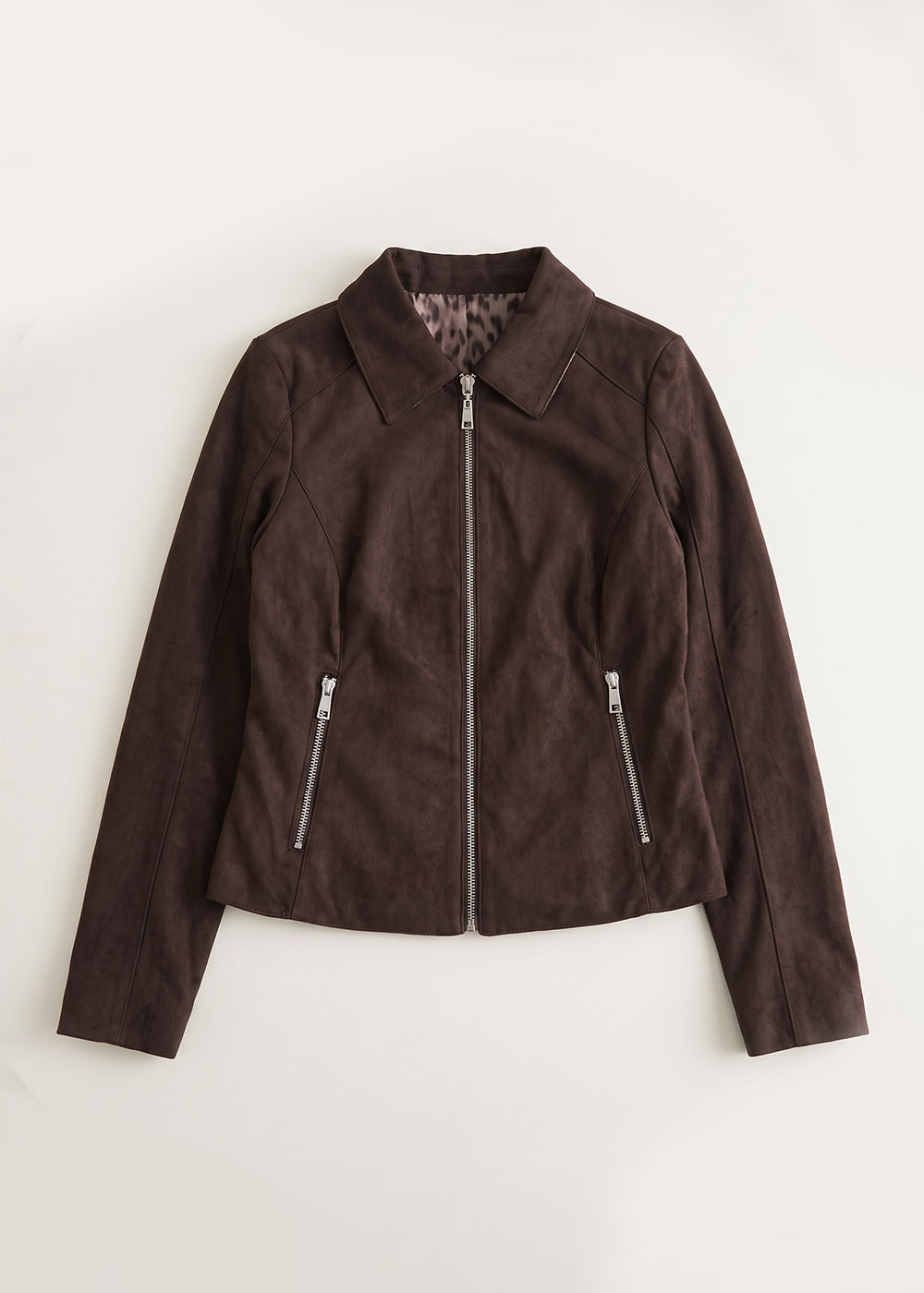 Dark brown suede women's biker jacket with front silver zip and zipped pockets, pointed collar and leopard-print lining, flat-lay on white background