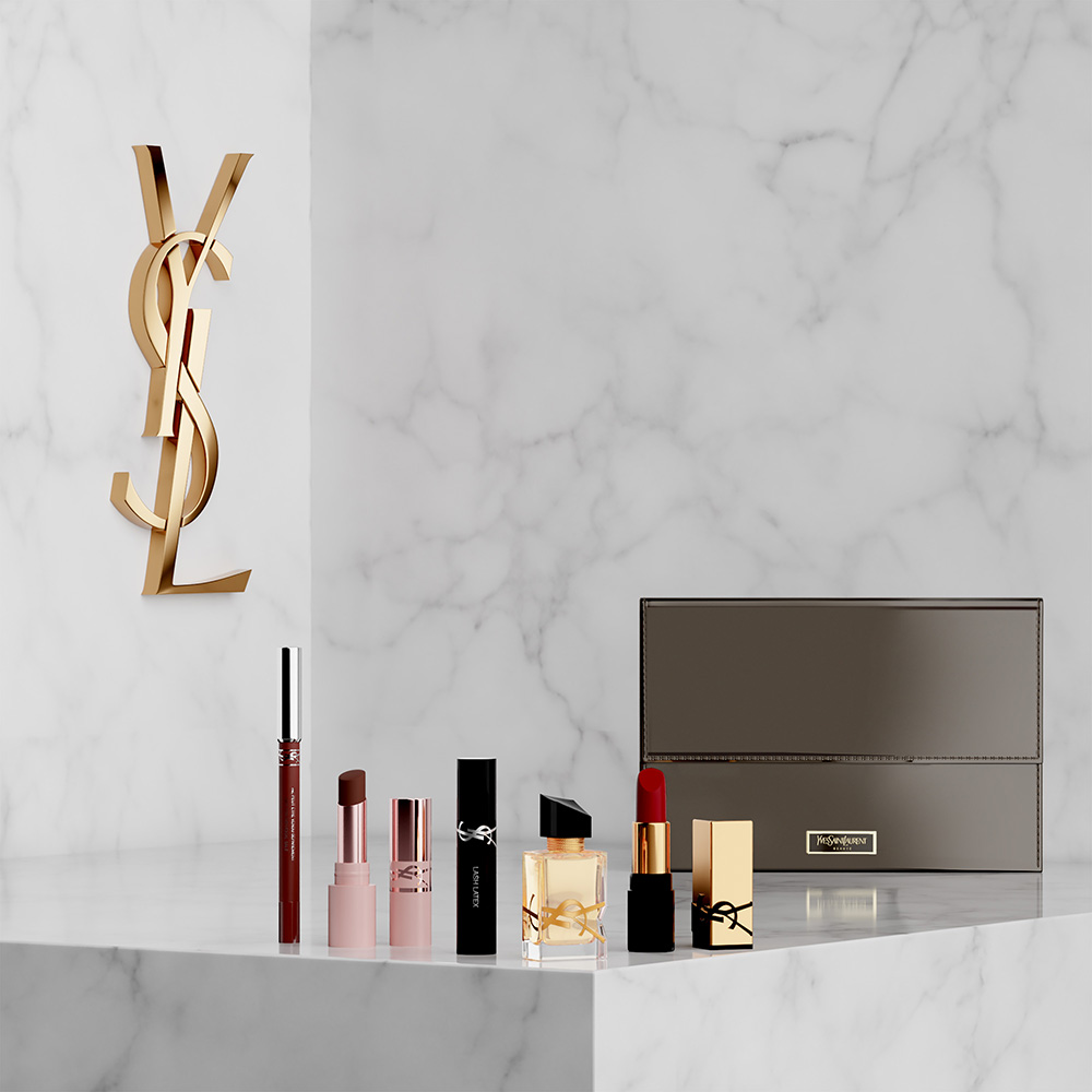 Una selezione di prodotti di bellezza YSL, rossetti e una pochette su un piedistallo di marmo accanto a un logo YSL dorato.