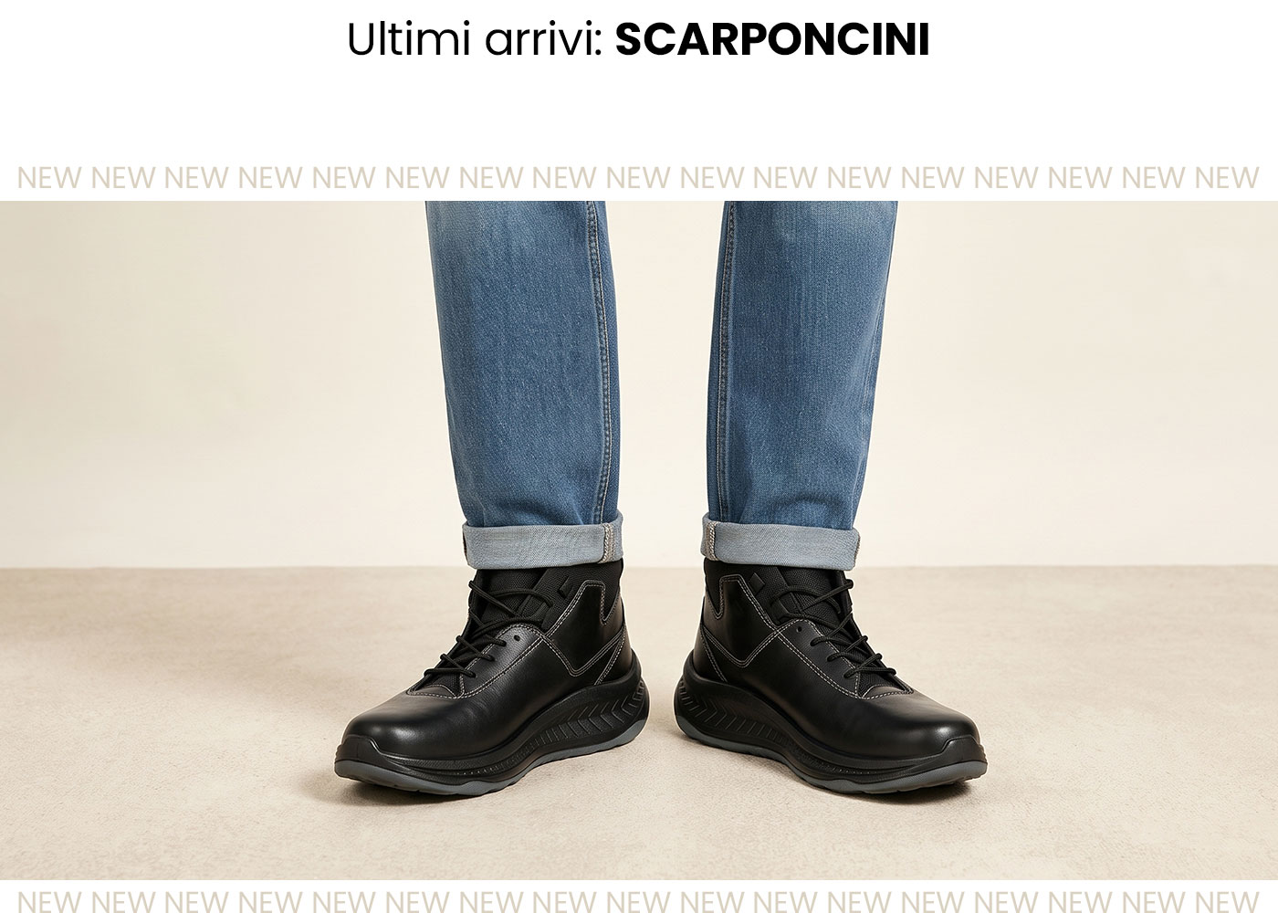Black leather ankle boots with laces worn with rolled-up blue jeans on model, studio shot on neutral background