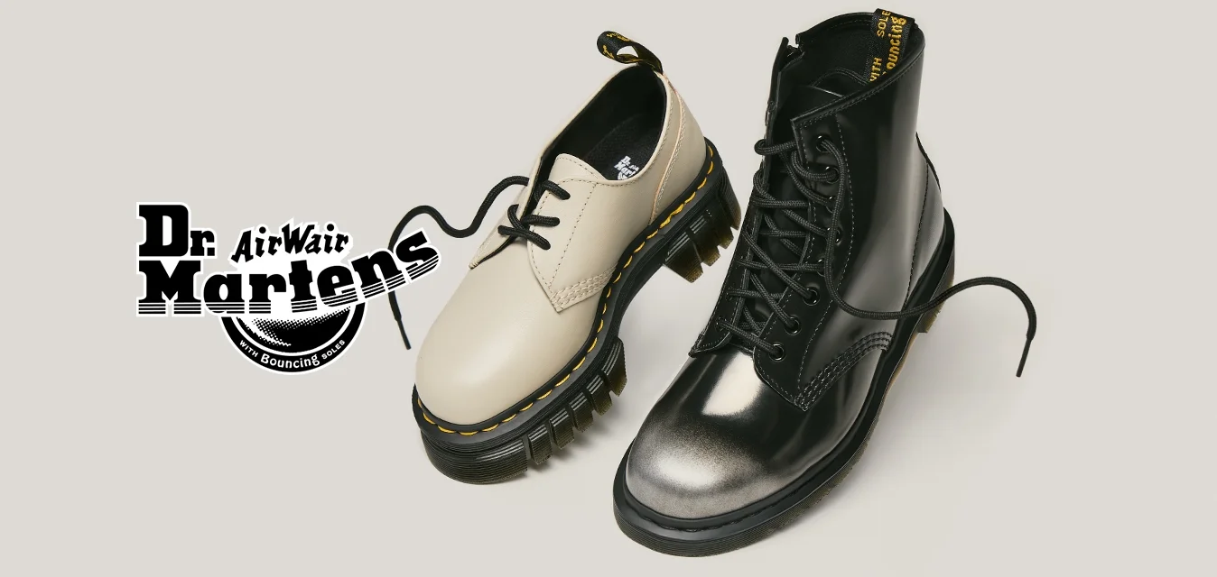 Una scarpa bassa beige e un stivale nero alto con lacci su uno sfondo semplice chiaro.