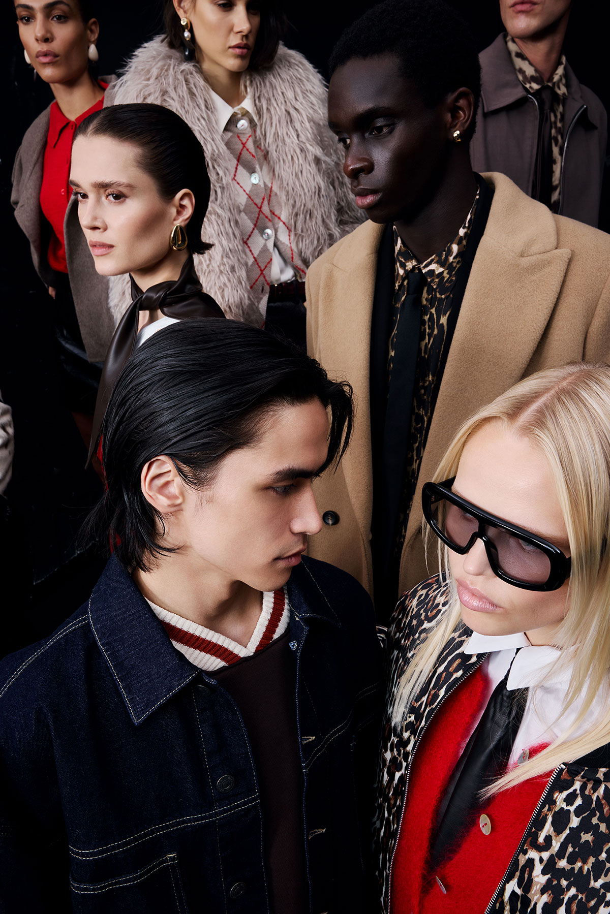 Group of diverse fashion models in autumn/winter designer coats, knitwear and accessories, close-up studio portrait