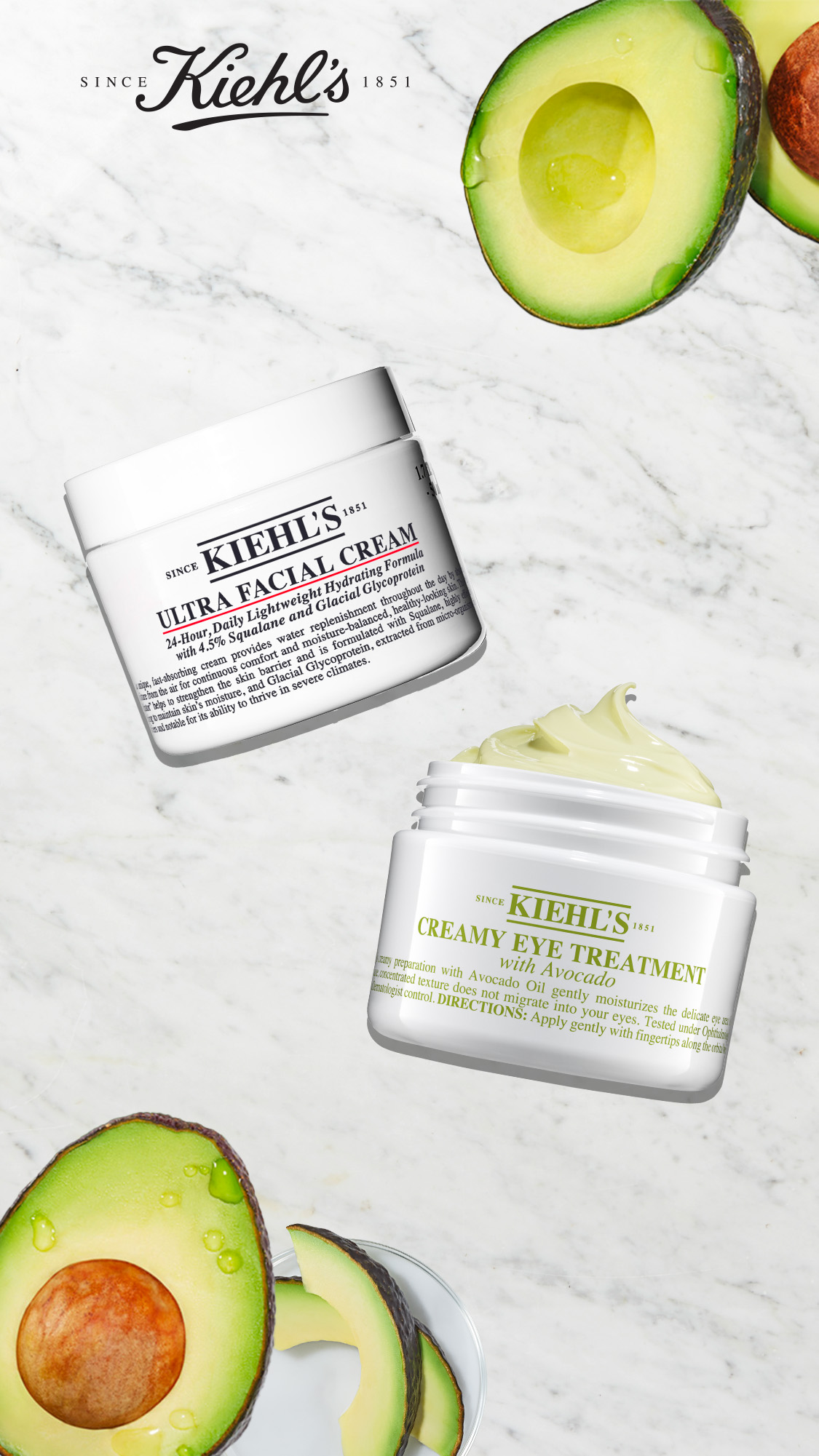 Ultra Facial Cream e Creamy Eye Treatment with avocado su sfondo di marmo bianco e degli avocado aperti