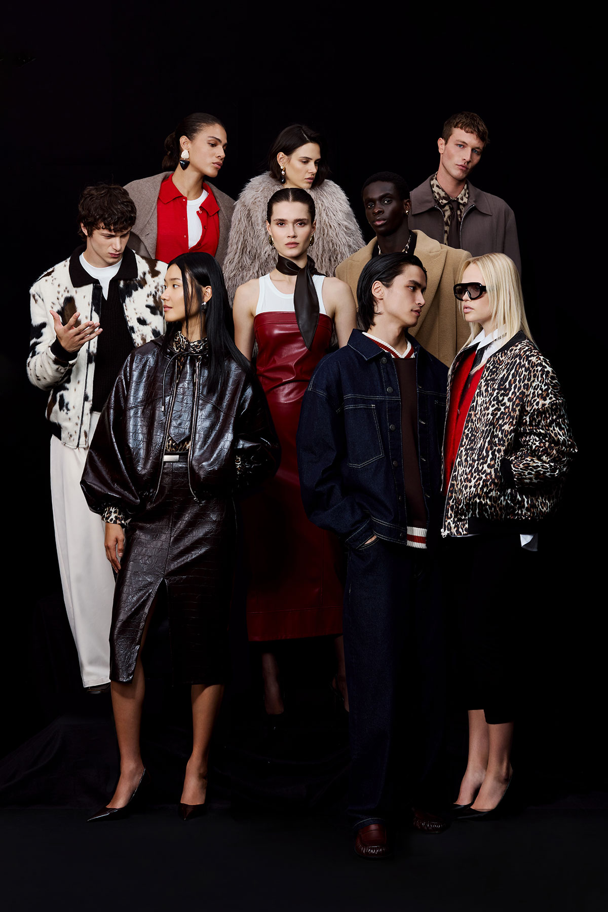 Diverse fashion models pose in autumn–winter looks: leather, fur, denim and patterned jackets on black background.