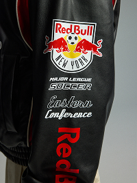 Primo piano della manica di una giacca nera con stampe Red Bull e Major League Soccer.