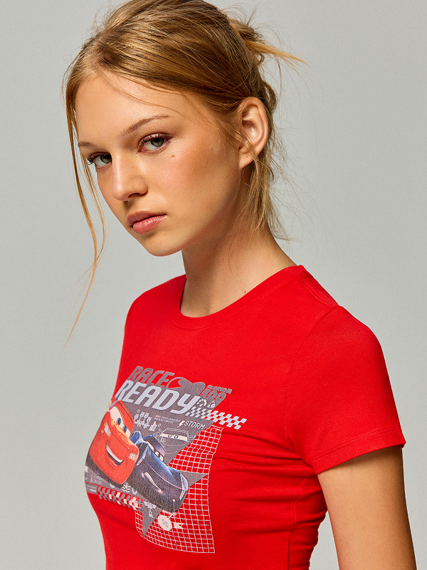 Donna con maglietta rossa e stampa Cars e Saetta McQueen.