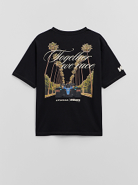 T-shirt nera con stampa di palme, città notturna e scritta decorativa.