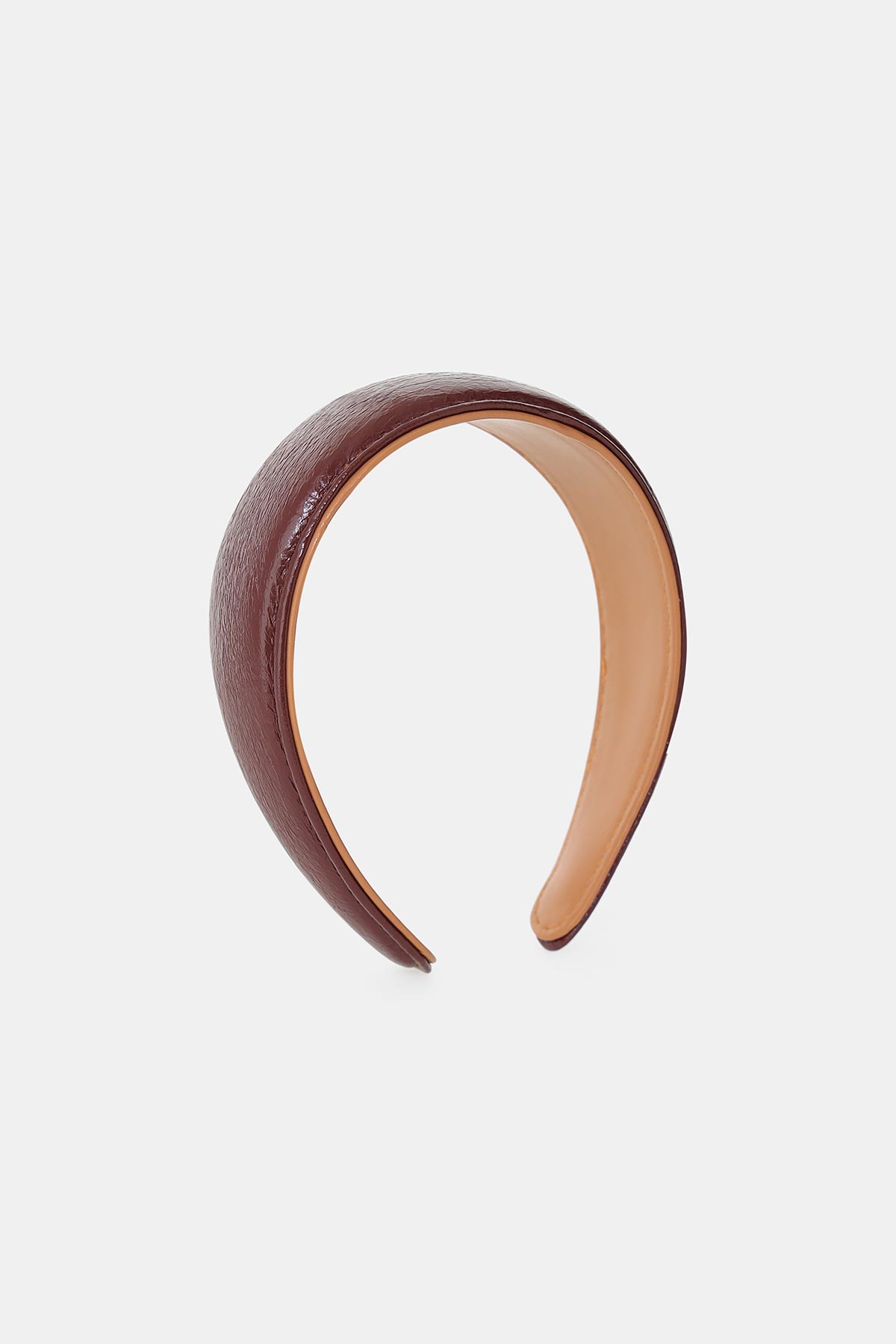 Padded brown faux-leather headband with tan inner lining, wide cushioned design on white background