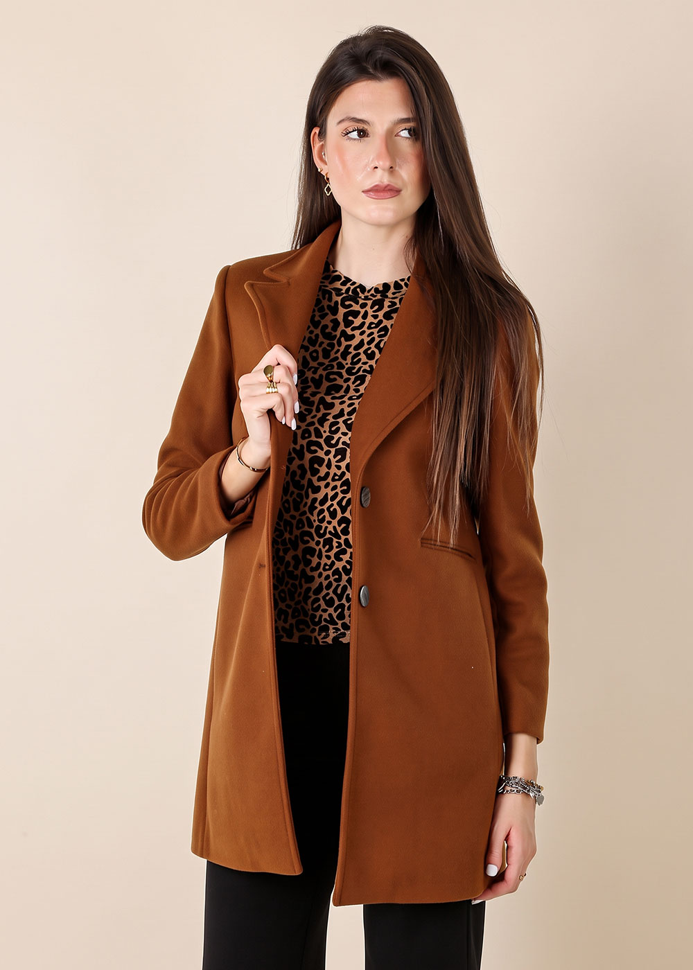 Woman model wearing brown single-breasted coat over leopard-print top, long straight hair, posing against neutral background
