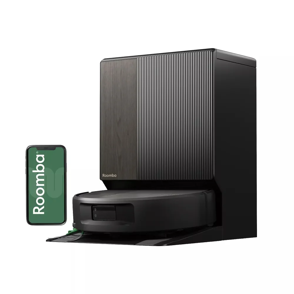 A black Roomba robot vacuum beside its charging dock and smartphone A black Roomba robot vacuum beside its charging dock and smartphone