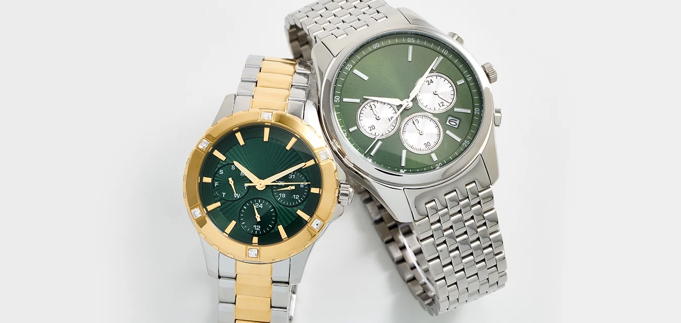 Due orologi da polso: uno con quadrante verde, accenti dorati e cinturino in argento; il secondo con quadrante verde, cinturino in argento e molteplici quadranti secondari.