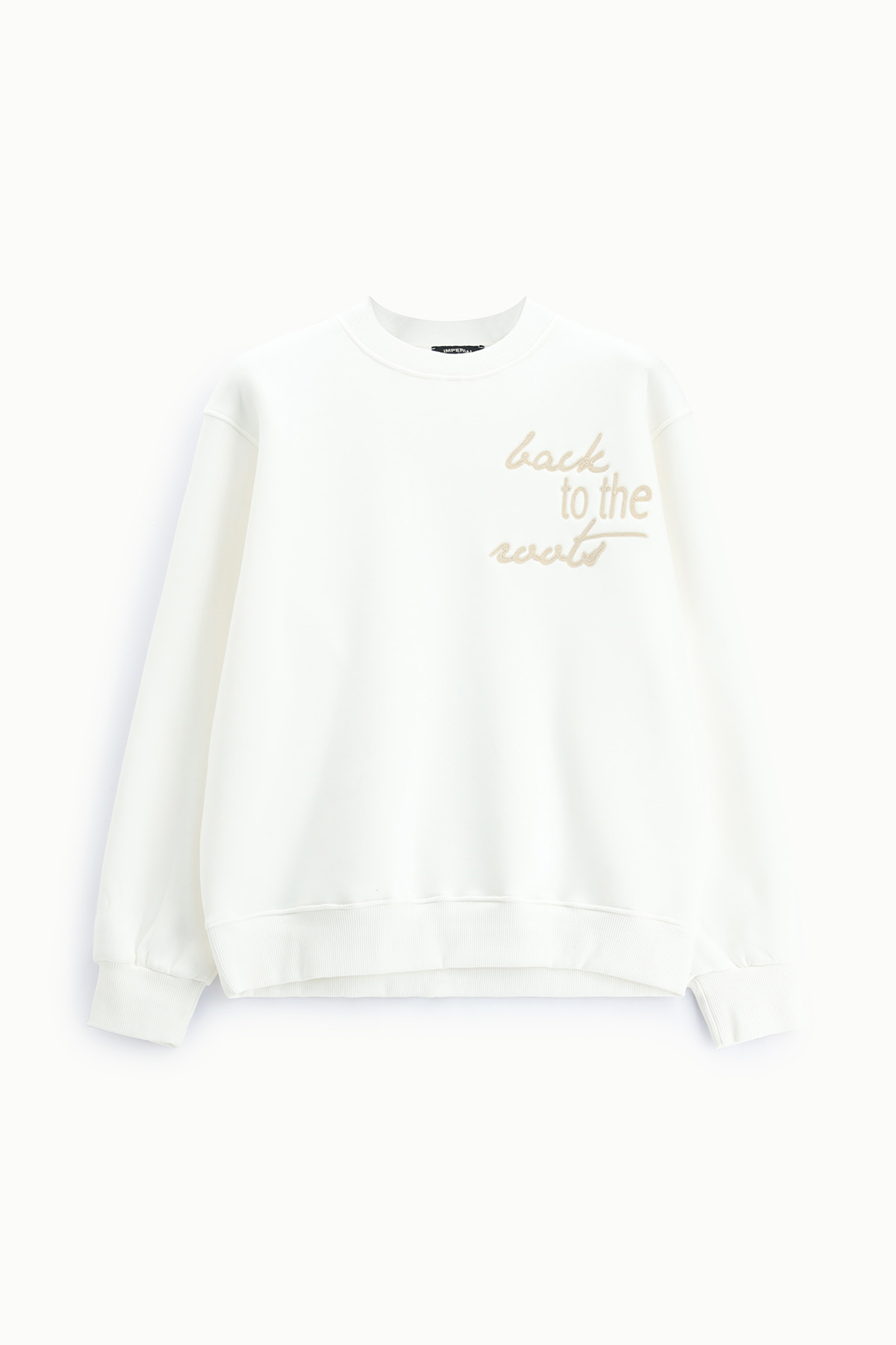 White crewneck sweatshirt with beige embroidered "back to the roots" slogan, long sleeves and ribbed cuffs