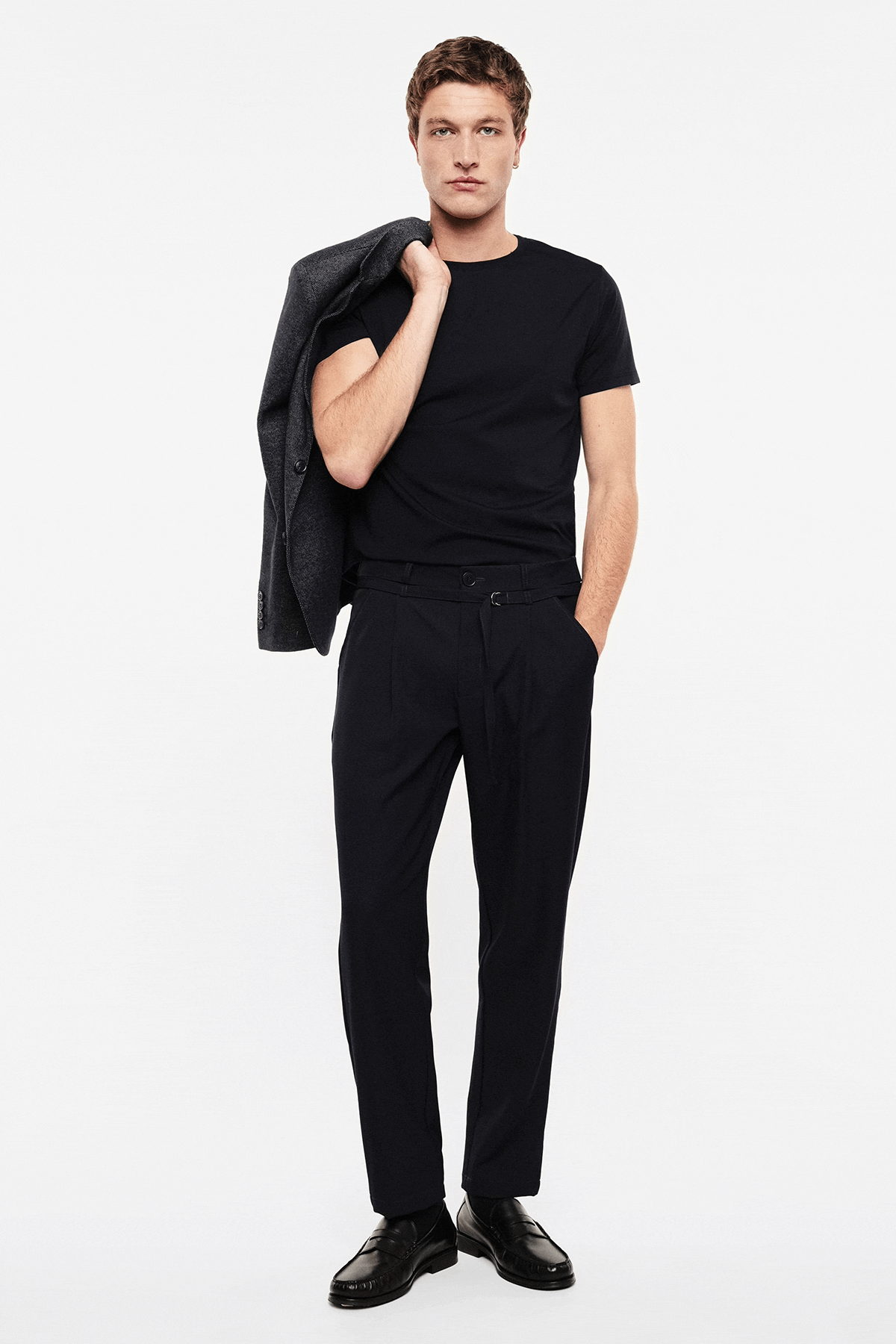 Collage of male model wearing black trousers and navy T-shirt with white sweater, front, back and close-up shots on white background