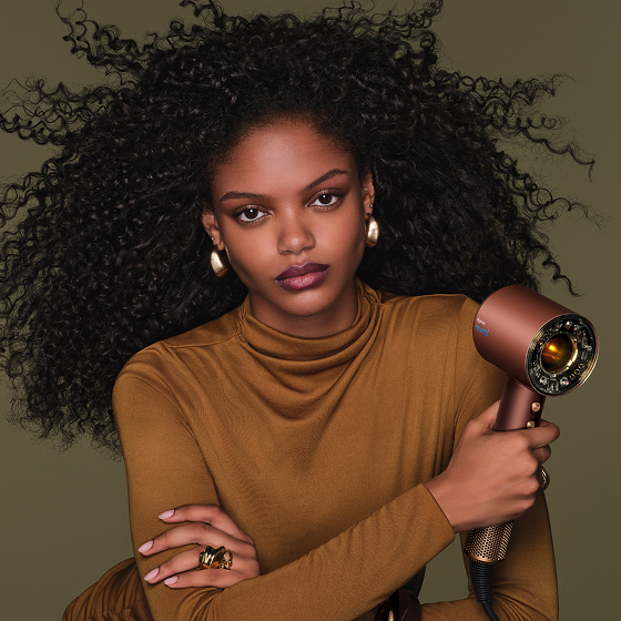 La modella asciuga i capelli con l'asciugacapelli Dyson Supersonic Nural.