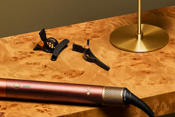 Dispositivo Dyson Beauty su un tavolo accanto a un set di fermagli per capelli Dyson.