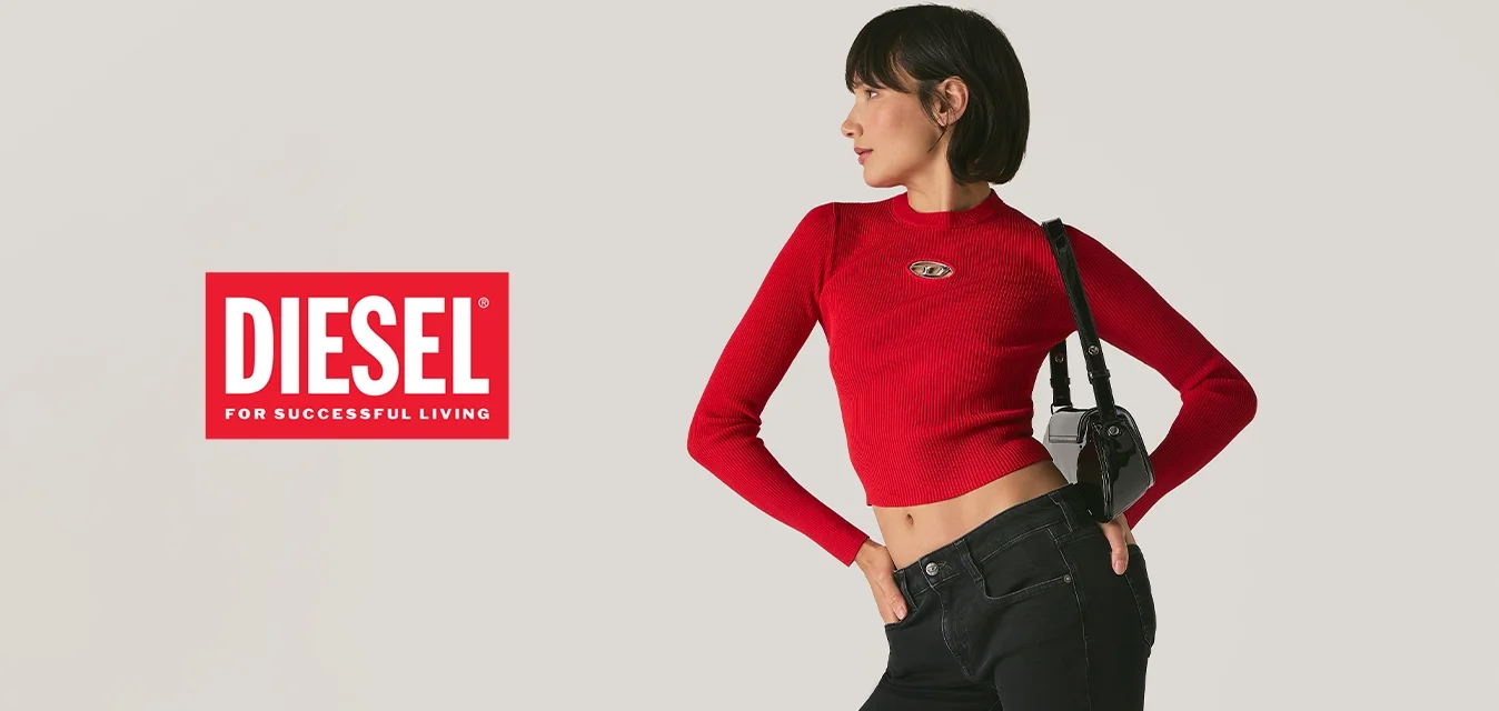 Donna in posa con jeans neri a zampa d'elefante, maglietta rossa a maniche lunghe cropped, sandali neri e una borsa a tracolla nera contro uno sfondo semplice.