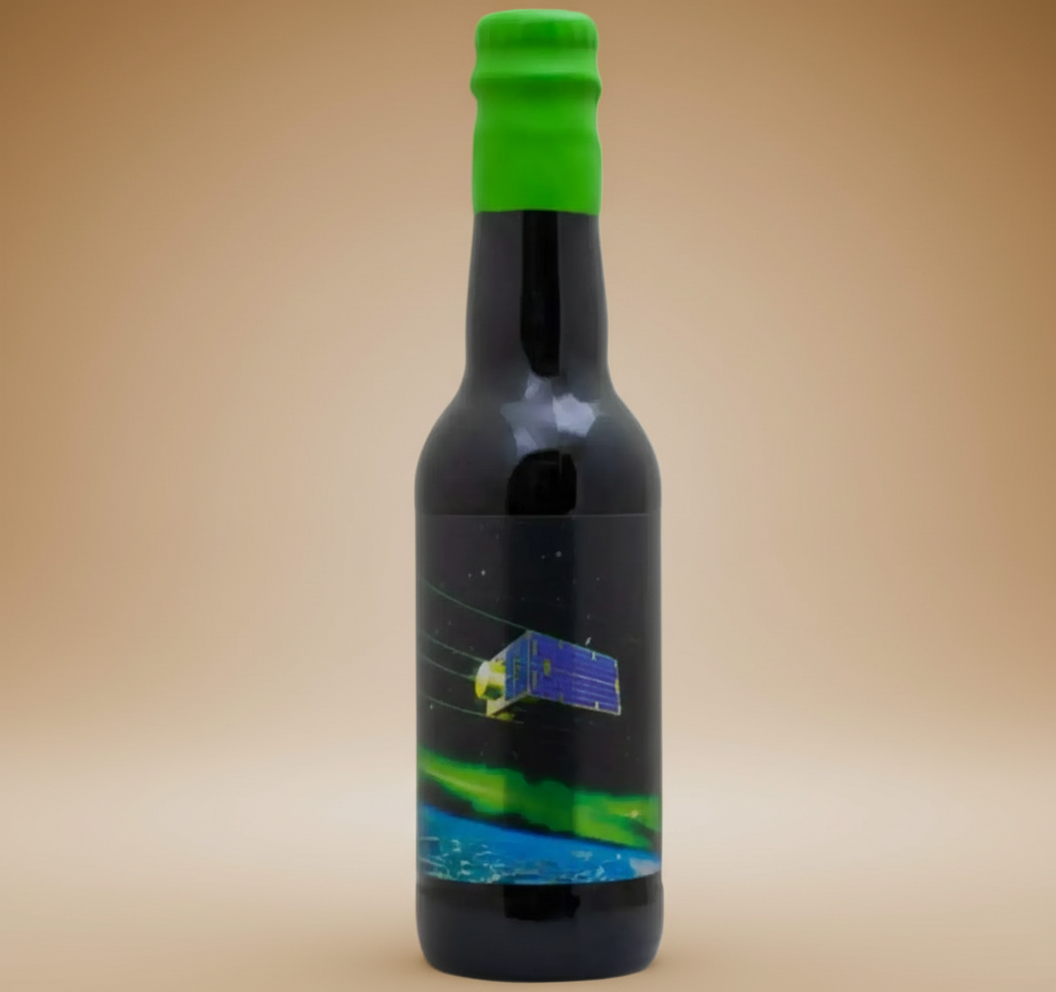 A dark bottle with a green cap and a label depicting a satellite above Earth's aurora.