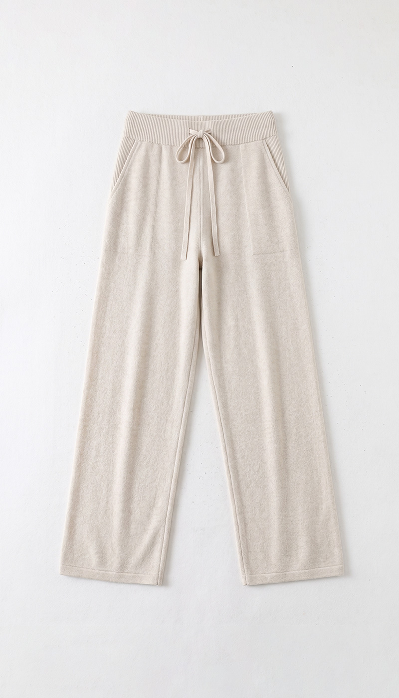 Beige women's wide-leg lounge trousers with ribbed drawstring waistband, front pockets and soft textured fabric on white background