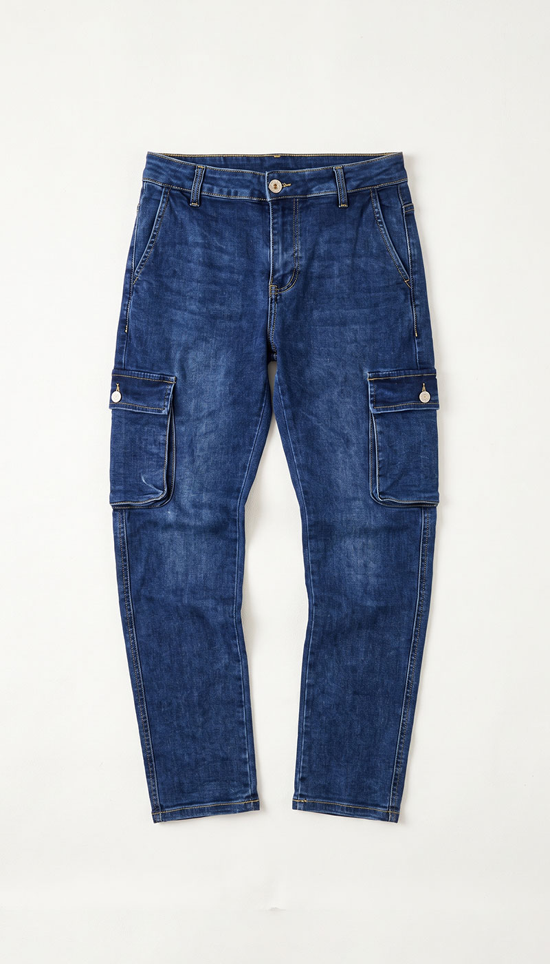 Flat-lay slim-fit blue denim cargo jeans with button fastening and side cargo pockets on white background