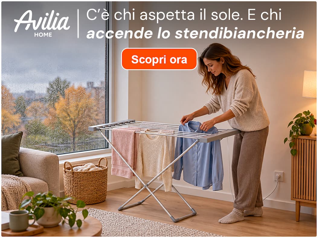 Donna che stende il bucato su uno stendibiancheria riscaldato Avilia, mentre fuori piove. C’è chi aspetta il sole. E chi accende lo stendibiancheria.