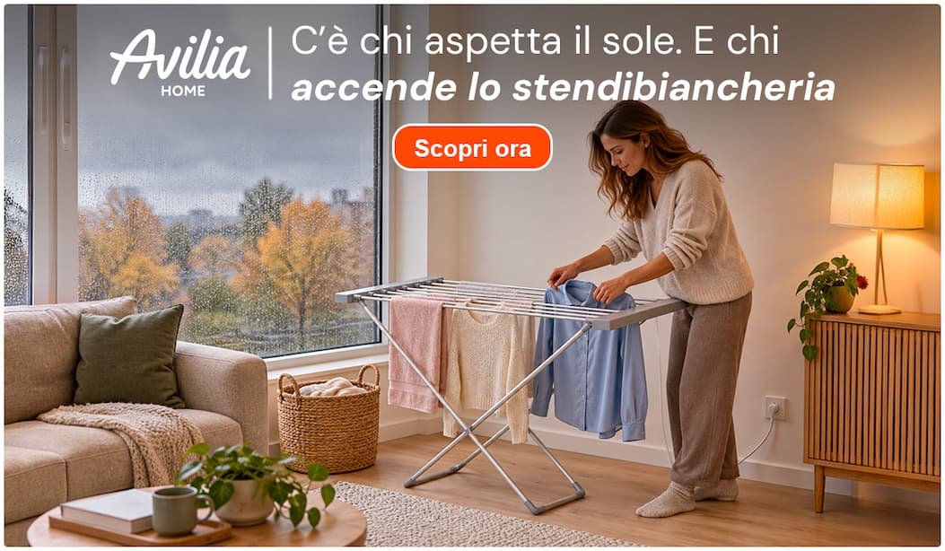 Donna che stende il bucato su uno stendibiancheria riscaldato Avilia, mentre fuori piove. C’è chi aspetta il sole. E chi accende lo stendibiancheria.