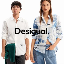 Uomo e donna stanno fianco a fianco indossando camicie bianche con motivi a bottoni e maniche arrotolate, l'uomo tiene in mano un maglione verde, la donna indossa jeans blu.