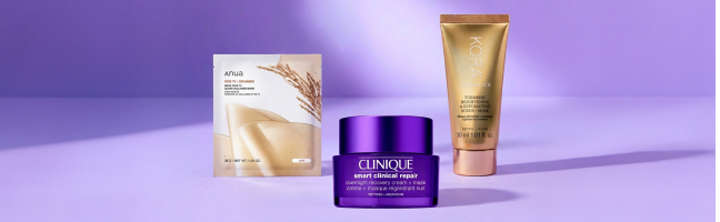 Prodotti per la cura del viso con maschera in tessuto, crema notte e maschera esfoliante su uno sfondo viola che richiama l’autunno.