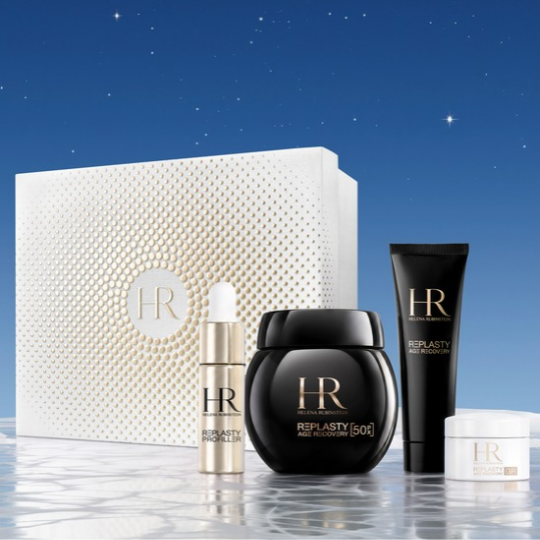 Cofanetto regalo festivo di Helena Rubinstein Replasty e i suoi prodotti disposti su un pavimento bianco e ghiacciato, valorizzati da un cielo notturno stellato in sottofondo.