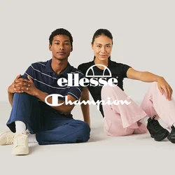 Due giovani adulti seduti per terra, uno con una camicia a righe e sneakers, l'altro con una camicia nera e pantaloni rosa.