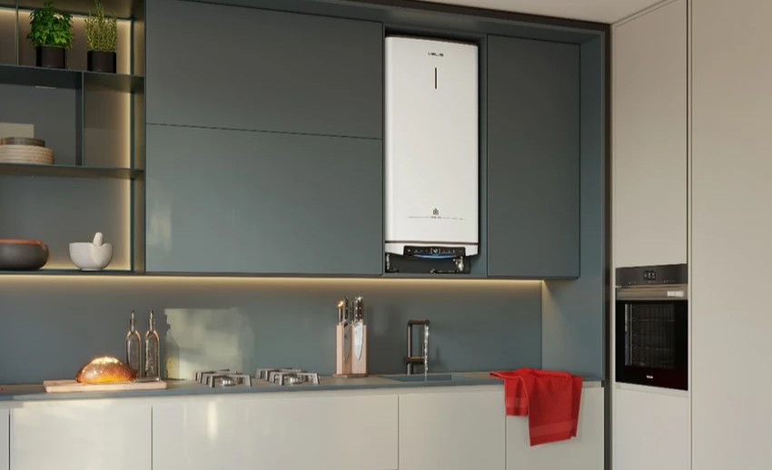 Modern kitchen with grey cabinets and countertop, wall-mounted white combi boiler above sink, gas hob, built-in oven, loaf of bread and red tea towel