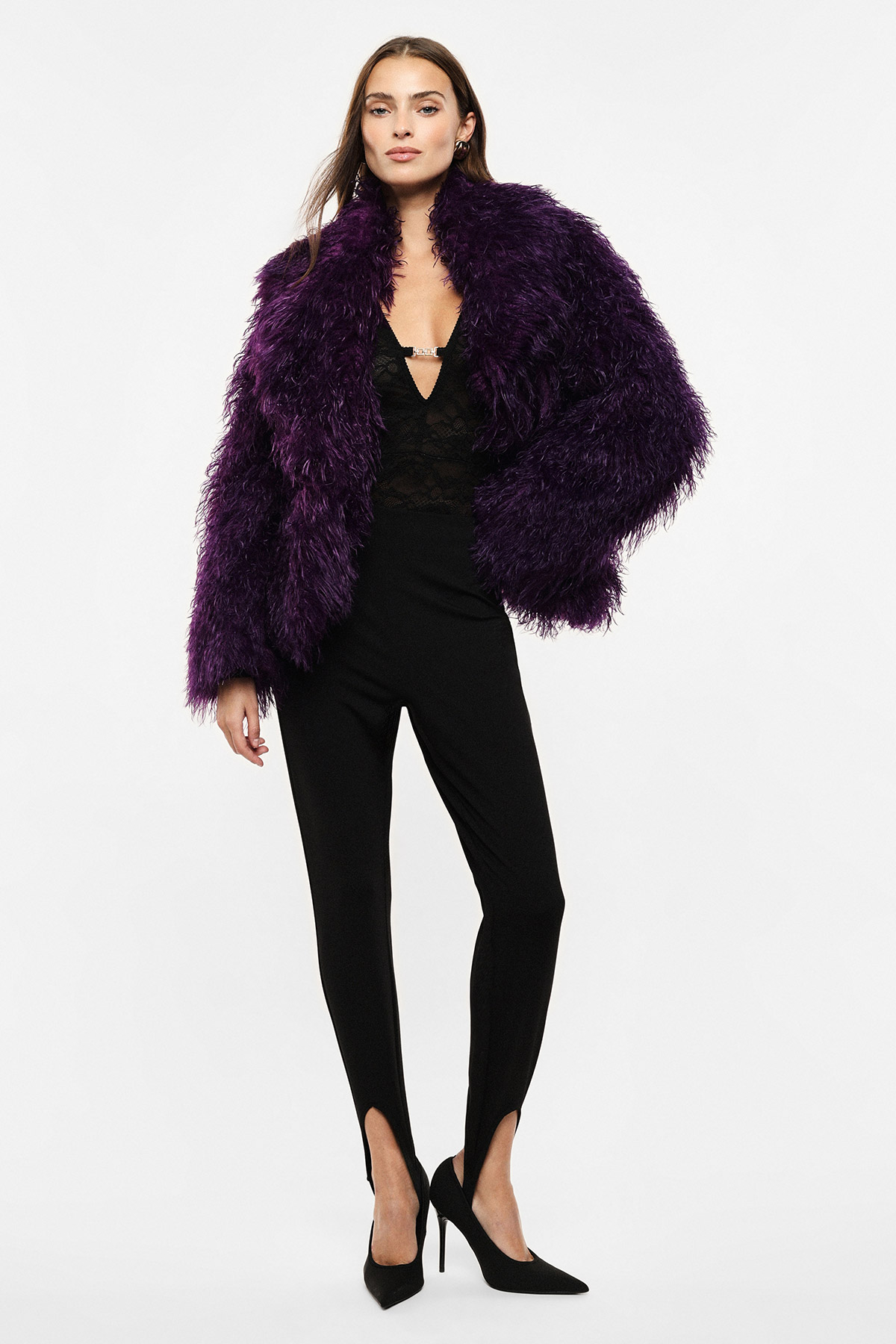 Model in purple faux-fur jacket over black lace plunging top, slim black trousers with front hem slits and black heels