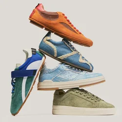Stack di cinque sneaker casual arancioni, blu, verdi e in stile denim disposte su uno sfondo chiaro e semplice.
