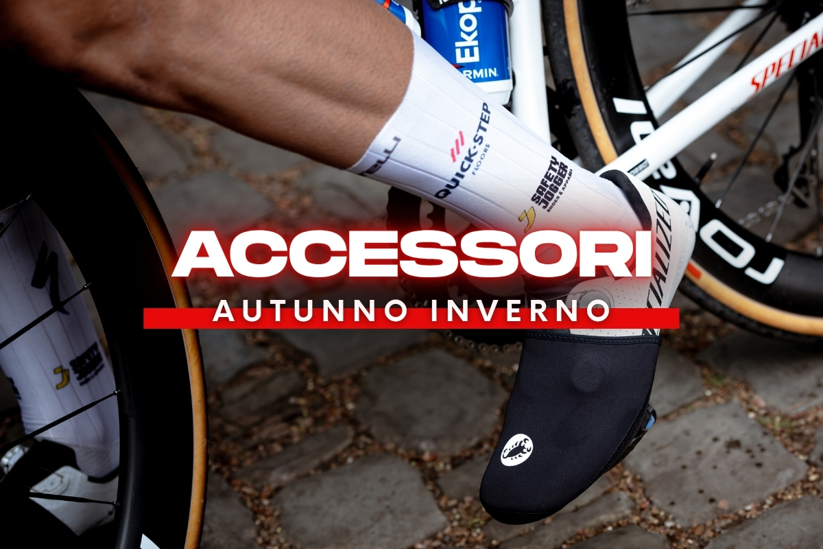 Cyclist's foot on pedal wearing a black winter overshoe and white sock, with 'ACCESSORI AUTUNNO INVERNO' banner overlaid