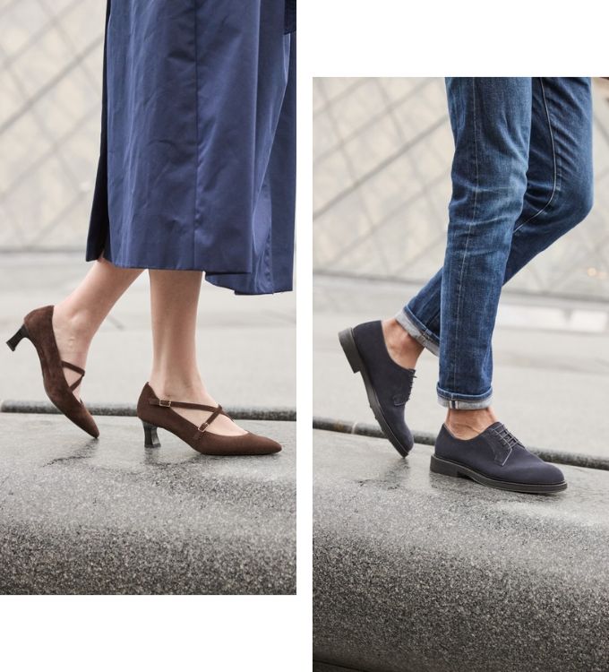 Side-by-side close-up of a woman's brown suede Mary Jane heels and a man's navy suede derby shoes worn with rolled jeans